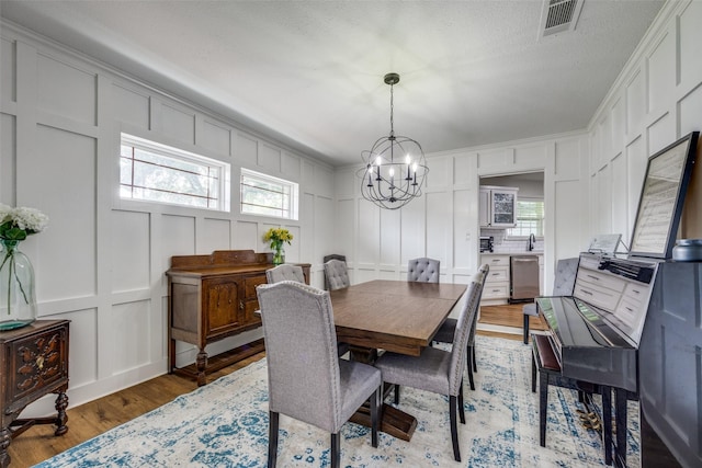 2208 Turtle Creek Dr, Sherman, TX 75092 - dining space with a decorative wall, a chandelier, light wood-style flooring, and healthy amount of natural light