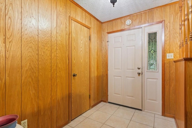 109 Hilltop St, Riesel, TX 76682 - foyer entrance featuring light tile patterned flooring, wood walls, ornamental molding, and a textured ceiling
