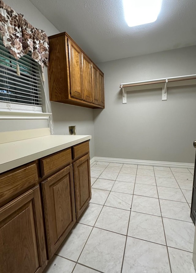 225 Jp Cave Rd, Sherman, TX 75090 - laundry area featuring cabinet space, hookup for a washing machine, baseboards, a textured ceiling, and light tile patterned flooring