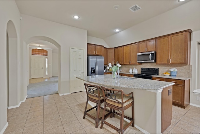 760 Red Elm Ln, Fort Worth, TX 76131 - kitchen featuring stainless steel appliances, arched walkways, a sink, lofted ceiling, and light tile patterned floors