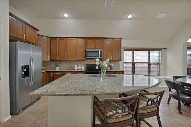 760 Red Elm Ln, Fort Worth, TX 76131 - kitchen featuring stainless steel appliances, light tile patterned floors, a kitchen bar, tasteful backsplash, and recessed lighting