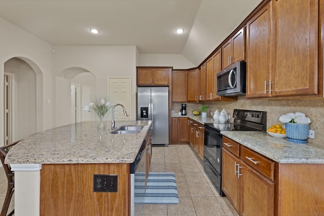 760 Red Elm Ln, Fort Worth, TX 76131 - kitchen featuring appliances with stainless steel finishes, a sink, tasteful backsplash, brown cabinets, and light stone countertops