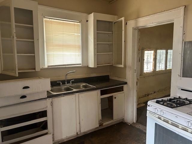 823 Centre, Dallas, TX 75208 - kitchen with white gas stove, a sink, dark countertops, and white cabinets