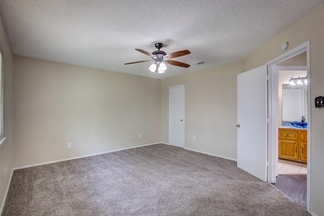 6729 Windwillow Dr, Fort Worth, TX 76137 - unfurnished bedroom with light colored carpet, a textured ceiling, ceiling fan, baseboards, and connected bathroom