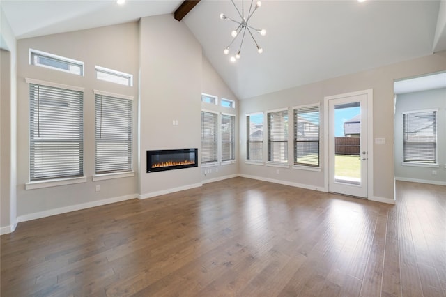 3493 Hollow Pine Dr, Frisco, TX 75033 - unfurnished living room with high vaulted ceiling, a chandelier, a glass covered fireplace, wood finished floors, and beam ceiling