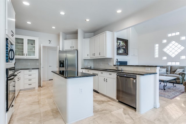 5916 Broadmoor Dr, Plano, TX 75093 - kitchen featuring appliances with stainless steel finishes, a sink, a kitchen island, tasteful backsplash, and a peninsula