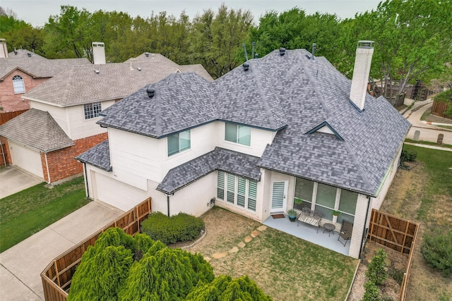 5916 Broadmoor Dr, Plano, TX 75093 - back of house featuring a chimney, a garage, concrete driveway, a shingled roof, and a patio area