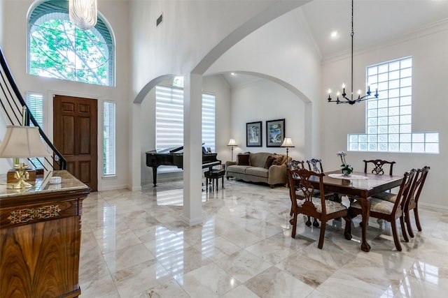 5916 Broadmoor Dr, Plano, TX 75093 - dining area featuring light marble finish flooring, a chandelier, a towering ceiling, ornamental molding, and arched walkways