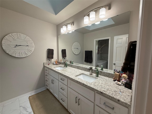 3417 Danbury Dr, Amarillo, TX 79109 - full bath featuring double vanity, marble look tiles, baseboards, and a tub to relax in