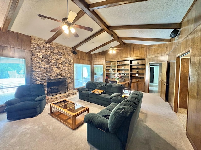 1107 Rock Springs Rd, Duncanville, TX 75137 - living area featuring wood walls, ceiling fan, a textured ceiling, light colored carpet, and a fireplace