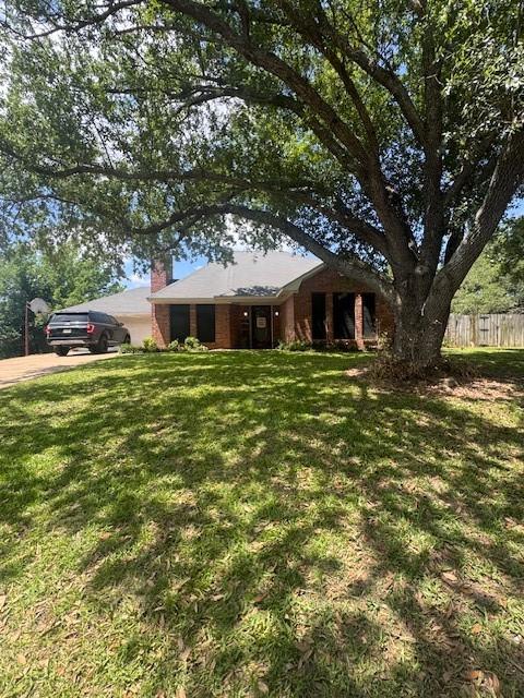 226 Colonial Cir, Athens, TX 75751 - single story home with concrete driveway, an attached garage, and a chimney