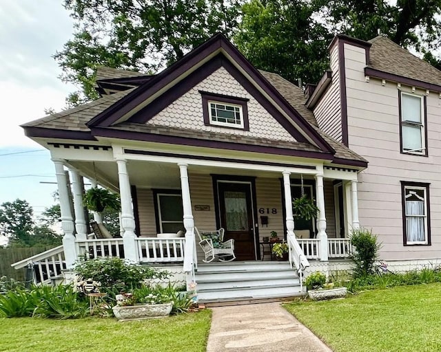 618 W Chestnut St, Denison, TX 75020 - victorian house featuring covered porch, roof with shingles, and a front yard