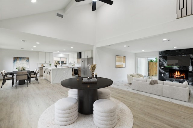 1309 Northpark Dr, Richardson, TX 75081 - living area featuring light wood finished floors, a fireplace, high vaulted ceiling, ceiling fan, and recessed lighting