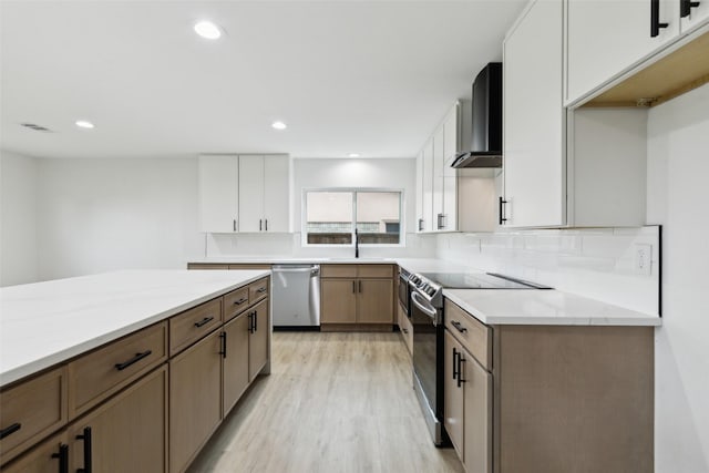 1309 Northpark Dr, Richardson, TX 75081 - kitchen featuring stainless steel appliances, wall chimney range hood, light wood-style flooring, a sink, and tasteful backsplash