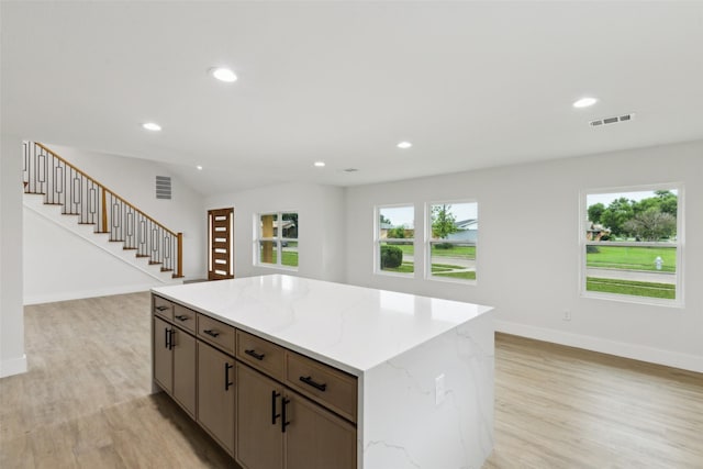 1309 Northpark Dr, Richardson, TX 75081 - kitchen with light wood-type flooring, a center island, baseboards, recessed lighting, and light stone counters