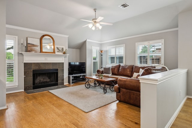 7308 Claridge Ln, Mckinney, TX 75072 - living room with ceiling fan, a tiled fireplace, wood finished floors, baseboards, and vaulted ceiling