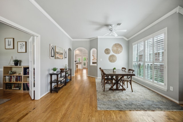 7308 Claridge Ln, Mckinney, TX 75072 - dining space with arched walkways, wood finished floors, ceiling fan, baseboards, and crown molding