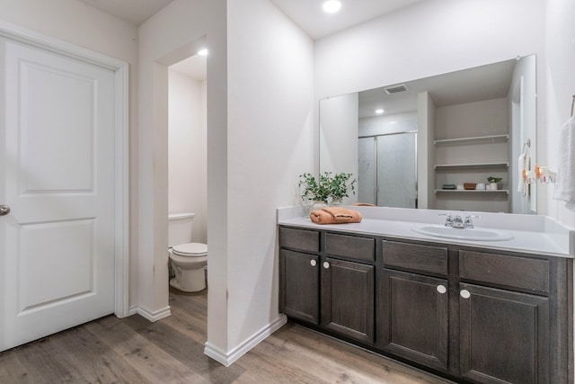 6514 Whitecap Dr, Princeton, TX 75407 - bathroom featuring wood finished floors, toilet, vanity, baseboards, and a shower with door