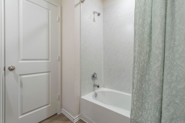 6514 Whitecap Dr, Princeton, TX 75407 - bathroom featuring wood finished floors, shower / bath combination, and baseboards