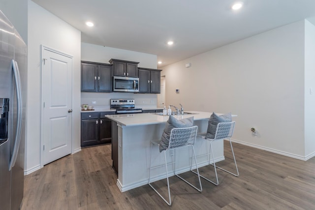 6514 Whitecap Dr, Princeton, TX 75407 - kitchen with stainless steel appliances, dark wood finished floors, an island with sink, a sink, and recessed lighting