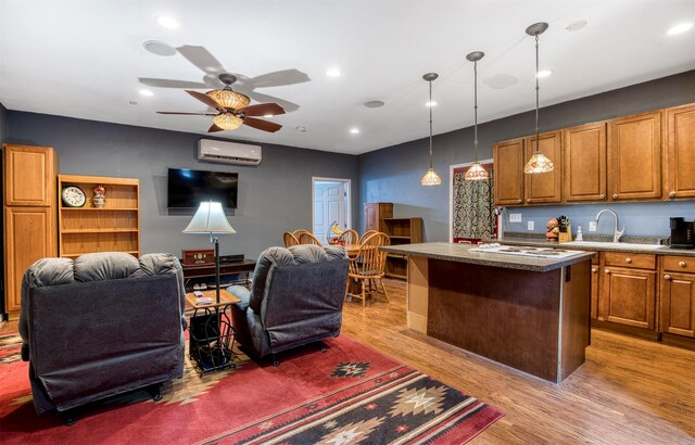 6811 Pecan St, Frisco, TX 75034 - kitchen featuring an AC wall unit, a sink, a center island, open floor plan, and recessed lighting
