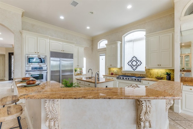 5528 Gleneagles Dr, Plano, TX 75093 - kitchen with built in appliances, a large island with sink, a sink, tasteful backsplash, and light stone countertops