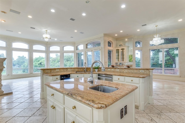 5528 Gleneagles Dr, Plano, TX 75093 - kitchen featuring a kitchen island with sink, a chandelier, ornamental molding, a sink, and stone tile floors