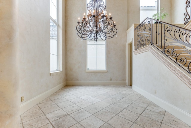 5528 Gleneagles Dr, Plano, TX 75093 - empty room featuring a chandelier, a towering ceiling, and baseboards