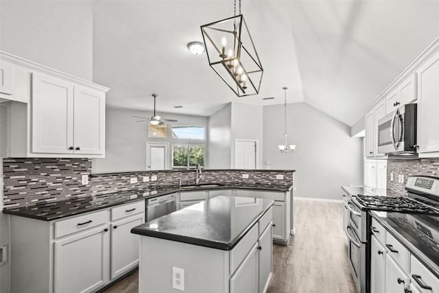 5409 Highlands Dr, Mckinney, TX 75070 - kitchen featuring appliances with stainless steel finishes, a peninsula, a chandelier, a sink, and vaulted ceiling