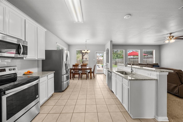 60 Misty Mesa Trl, Mansfield, TX 76063 - kitchen featuring stainless steel appliances, a sink, open floor plan, and white cabinets
