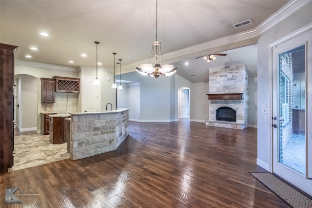 2326 Innisbrook Dr, Abilene, TX 79606 - unfurnished living room featuring arched walkways, ornamental molding, ceiling fan, a fireplace, and wood finished floors