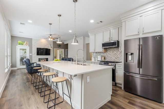 142 Shelby Trce, Murphy, TX 75094 - kitchen featuring stainless steel appliances, a sink, a ceiling fan, a fireplace, and backsplash