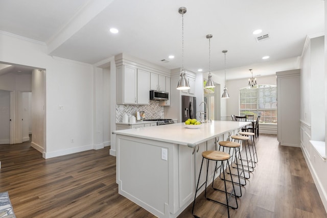 142 Shelby Trce, Murphy, TX 75094 - kitchen featuring appliances with stainless steel finishes, ornamental molding, dark wood-type flooring, a large island with sink, and backsplash