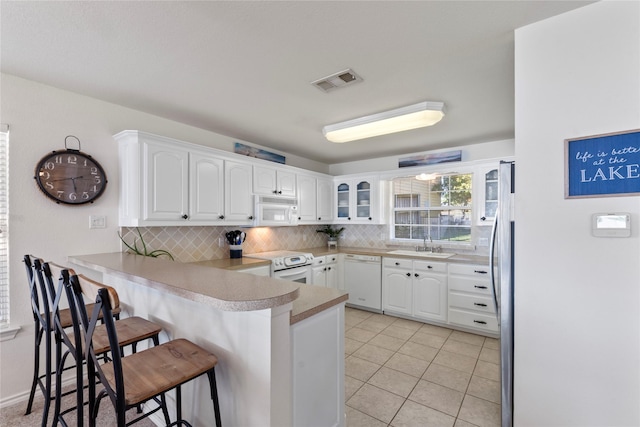431 Jib Dr, Gun Barrel City, TX 75156 - kitchen featuring white appliances, a peninsula, a breakfast bar, tasteful backsplash, and white cabinets