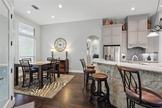 1447 Cimarron Trl, Hurst, TX 76053 - dining room with arched walkways, dark wood-style flooring, baseboards, and recessed lighting