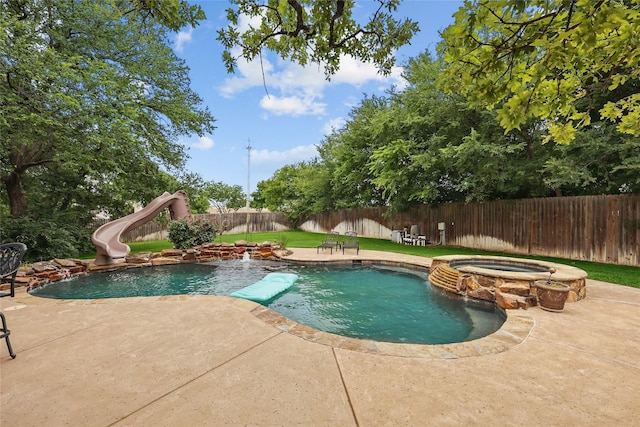 1447 Cimarron Trl, Hurst, TX 76053 - view of pool featuring a water slide, a pool with connected hot tub, a fenced backyard, and a patio