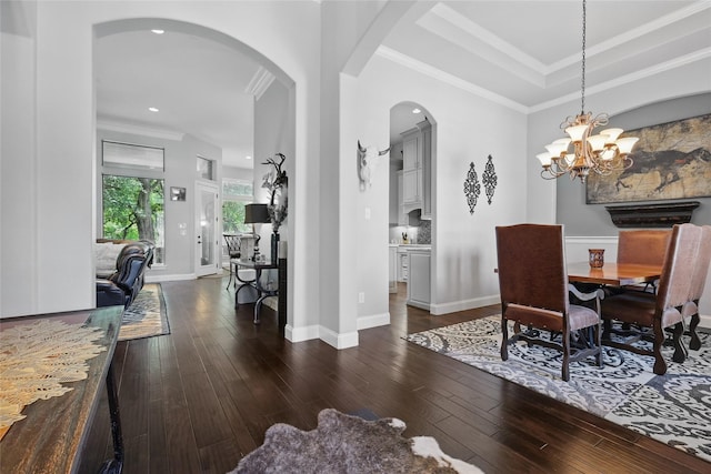 1447 Cimarron Trl, Hurst, TX 76053 - dining area with dark wood finished floors, arched walkways, ornamental molding, recessed lighting, and a chandelier