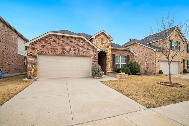 2341 Leeward Pl, Little Elm, TX 75068 - traditional-style home featuring concrete driveway, a front yard, brick siding, an attached garage, and stone siding