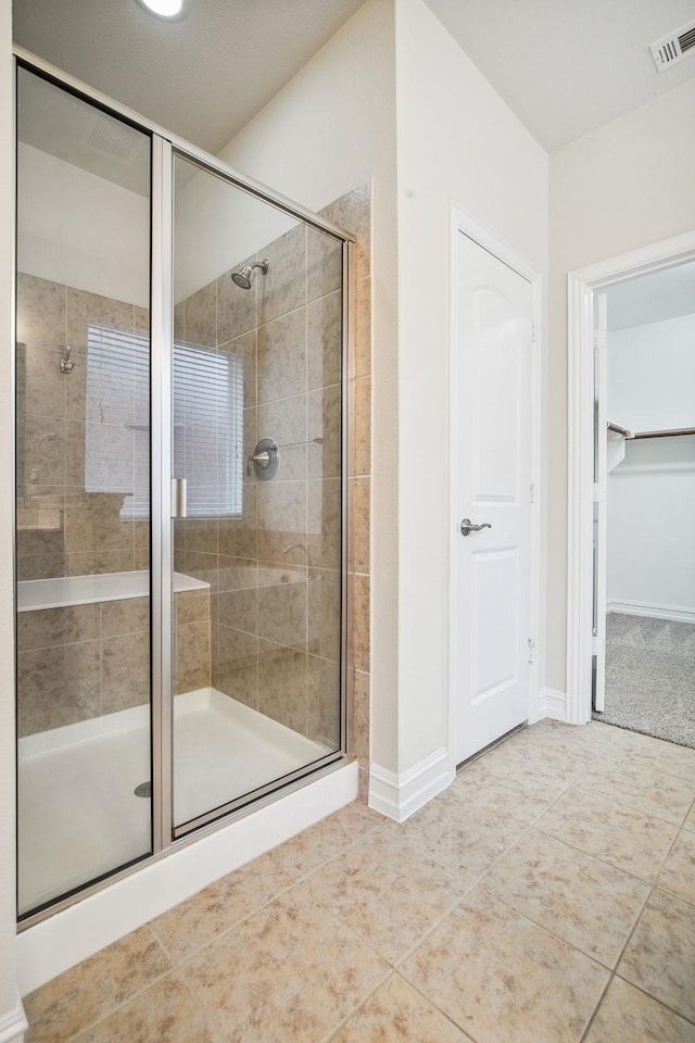2341 Leeward Pl, Little Elm, TX 75068 - bathroom with a stall shower, tile patterned flooring, a spacious closet, and baseboards