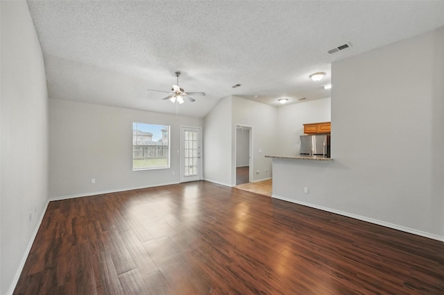 1412 Mockingbird Ln, Desoto, TX 75115 - unfurnished living room with ceiling fan, baseboards, wood finished floors, a textured ceiling, and vaulted ceiling