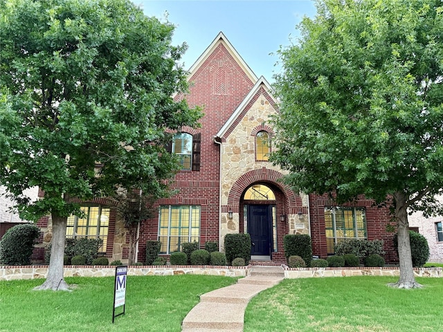 4561 Firewheel Dr, Plano, TX 75024 - tudor-style house with stone siding, brick siding, and a front lawn