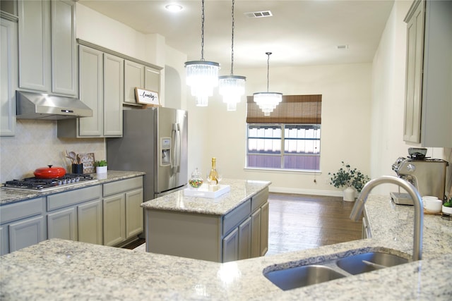 4561 Firewheel Dr, Plano, TX 75024 - kitchen featuring under cabinet range hood, a sink, appliances with stainless steel finishes, wood finished floors, and decorative backsplash