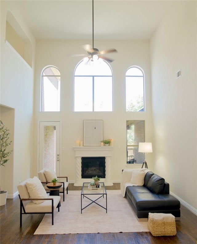4561 Firewheel Dr, Plano, TX 75024 - living area featuring a high ceiling, a ceiling fan, wood finished floors, a glass covered fireplace, and baseboards