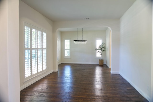 4561 Firewheel Dr, Plano, TX 75024 - empty room with arched walkways, dark wood-style floors, and baseboards