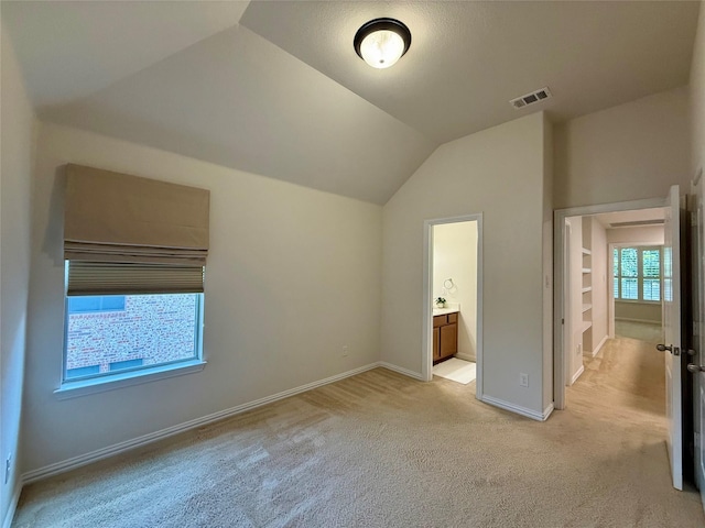 4561 Firewheel Dr, Plano, TX 75024 - unfurnished bedroom with light carpet, vaulted ceiling, baseboards, and connected bathroom