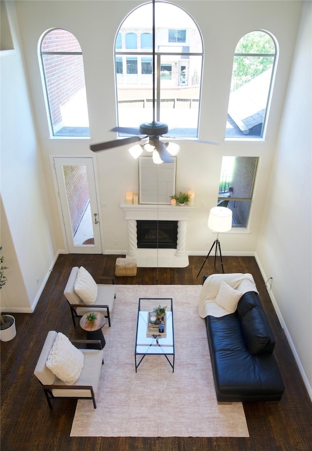 4561 Firewheel Dr, Plano, TX 75024 - living room featuring ceiling fan, wood finished floors, baseboards, a fireplace, and a towering ceiling