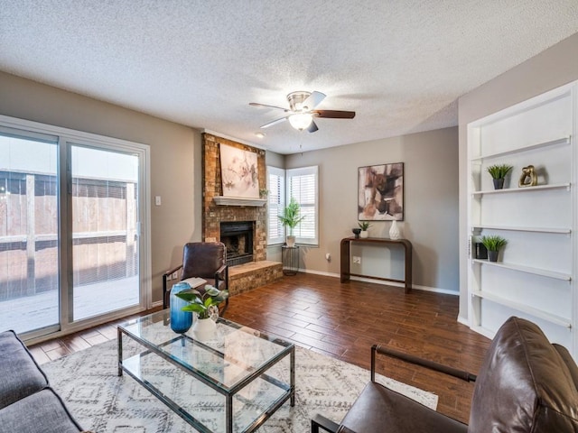 46 Morrow Dr, Bedford, TX 76021 - living area featuring ceiling fan, a large fireplace, baseboards, built in features, and a textured ceiling