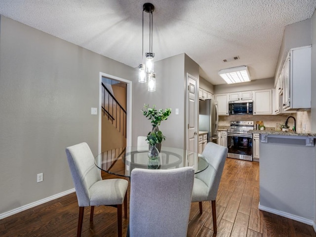 46 Morrow Dr, Bedford, TX 76021 - dining area featuring dark wood-type flooring, baseboards, stairs, and a textured ceiling