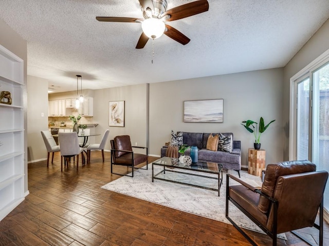 46 Morrow Dr, Bedford, TX 76021 - living area with a ceiling fan, a textured ceiling, dark wood-style flooring, and baseboards