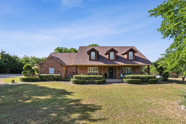 7968 Fm 121, Van Alstyne, TX 75495 - cape cod house featuring a front yard, brick siding, and a shingled roof